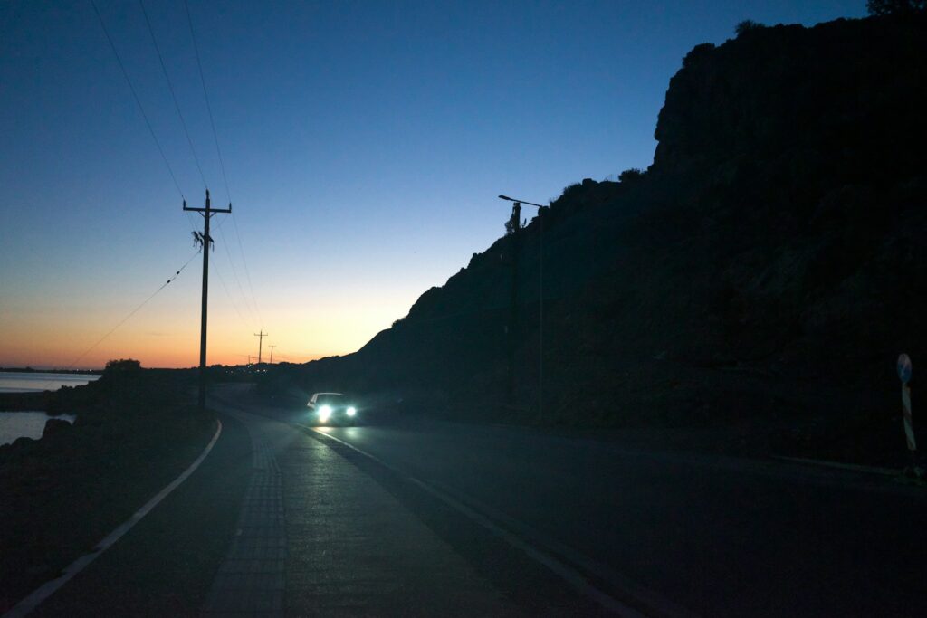 A car driving down a road next to the ocean