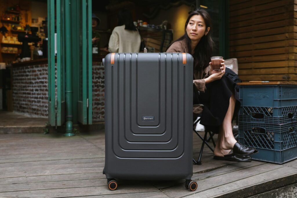 a woman sitting on a porch next to a piece of luggage